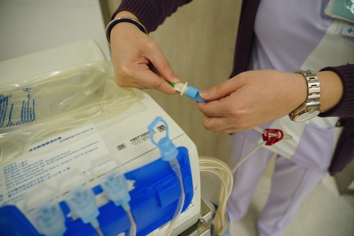「新式腹膜透析」洗腎邊睡邊做 兼顧生活品質 DSC09114 通稿 護理人員示範操作 接上管線使用