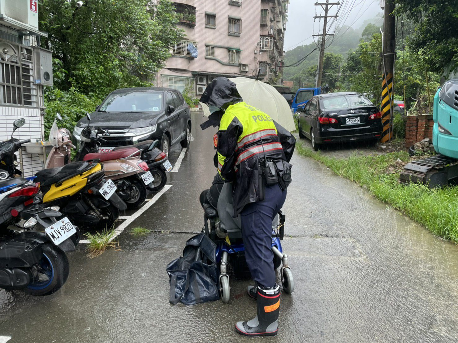 身障男電動車故障受困路中,迴龍派出所員警雨中徒手推車協助返家。圖:諶志明翻攝 身障男電動車故障受困路中,迴龍派出所員警雨中徒手推車協助返家。圖:諶志明翻攝