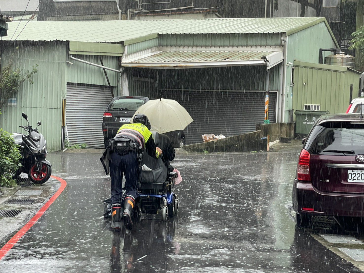 身障男電動車故障受困路中,迴龍派出所員警雨中徒手推車協助返家。圖:諶志明翻攝 身障男電動車故障受困路中,迴龍派出所員警雨中徒手推車協助返家。圖:諶志明翻攝