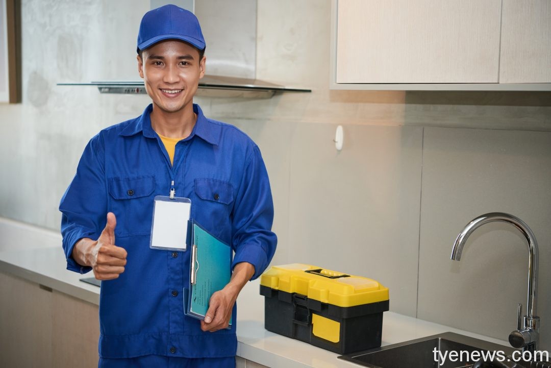 桃園優良移工選拔開跑 可獲得3600禮券 cheerful asian plumber standing near kitchen sink showing thumb up