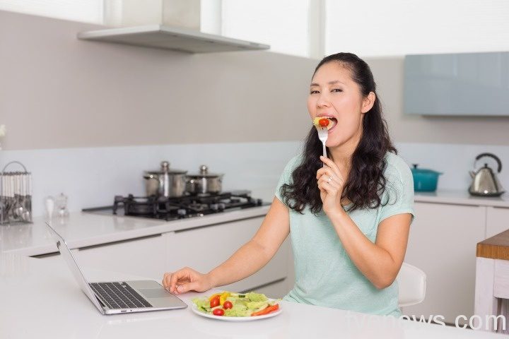 靠168斷食法 疫情解封後來個華麗登場! young woman with laptop eating salad kitchen