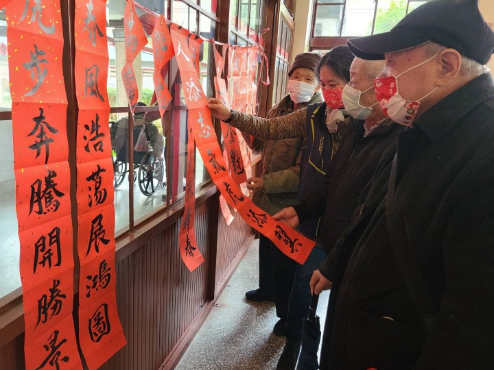 桃園榮家爺奶舞文弄墨 揮毫春聯寫下新希望 長輩仔細端詳欣賞春聯之美感受年節氣氛