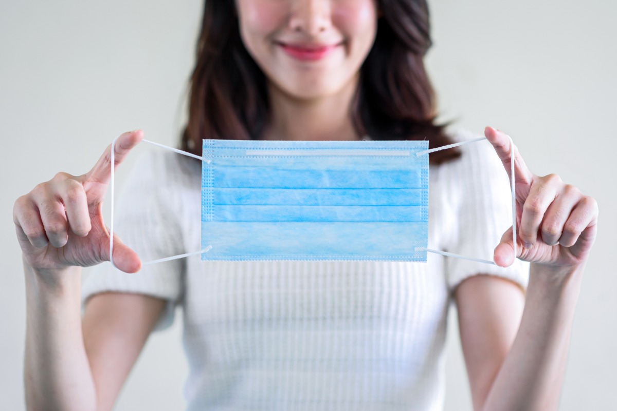 12月新制一次看!戶外口罩解封 台鐵新增9種行動支付 young beautiful asian woman showing how wear medical mask showing how correctly wear hygiene surgical mask step by step white background