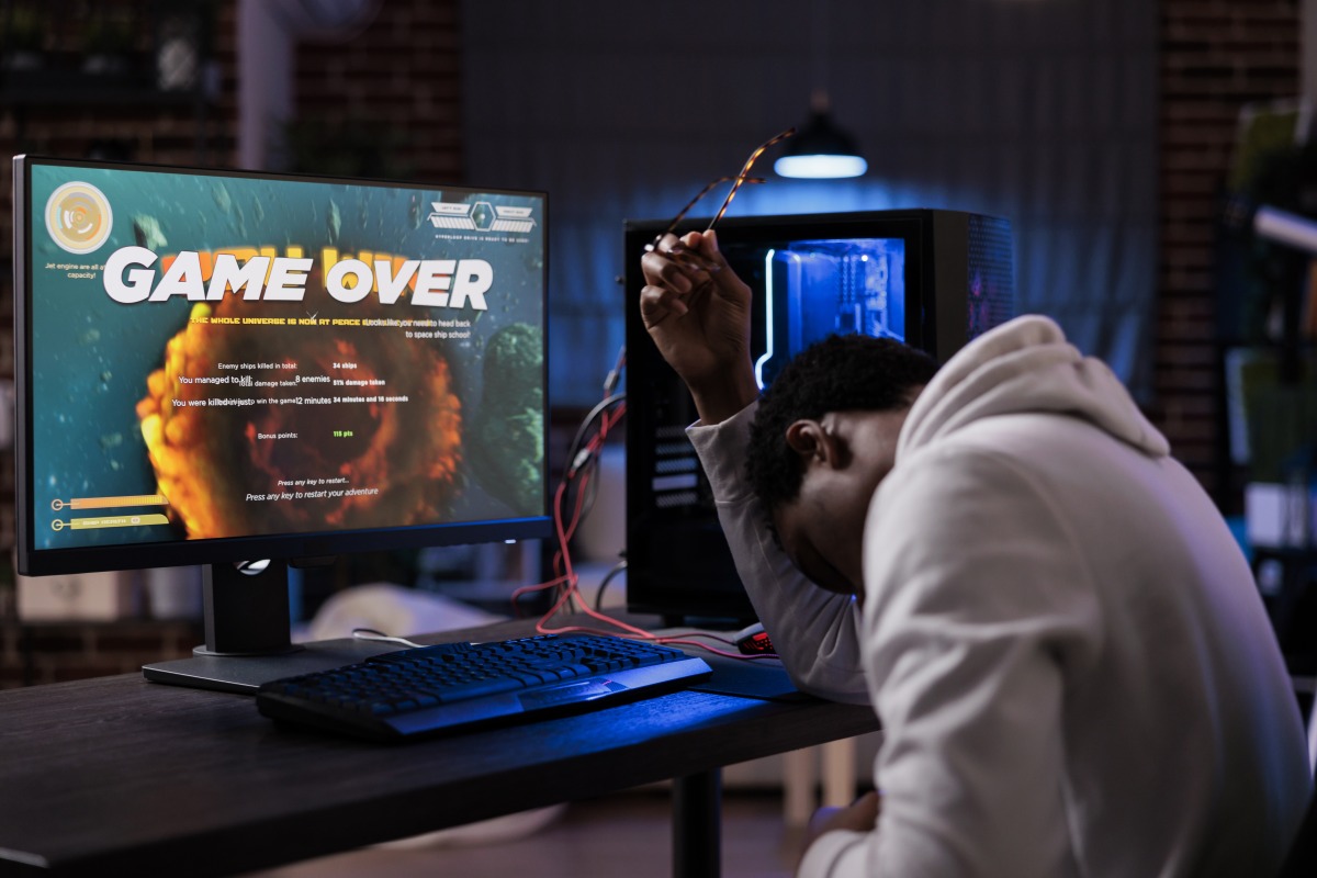 買賣遊戲帳號、虛寶停看聽 要求支付保證金恐是詐騙 frustrated streamer losing online shooter video games play competition computer with neon lights male gamer streaming action gameplay feeling sad about lost shooting championship