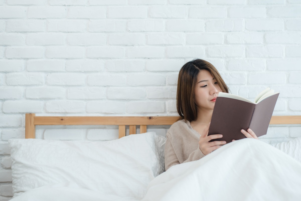 10種方式治癒心靈 重拾生活美好 lifestyle happy young asian woman enjoying lying bed reading book pleasure casual clothing