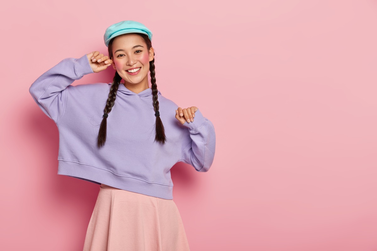 大寒將至!命理師曝開運妙招 過年上牌桌穿這色 positive fashionable teenage girl with makeup wears stylish cap purple sweatshirt skirt being good mood comes meeting with groupmates isolated pink wall