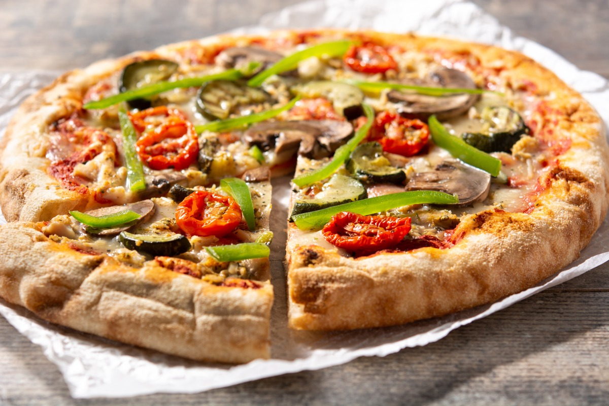 通膨衝擊!佛心老闆請全城免費吃披薩1個月 vegetarian pizza with zucchini tomato peppers mushrooms wooden table
