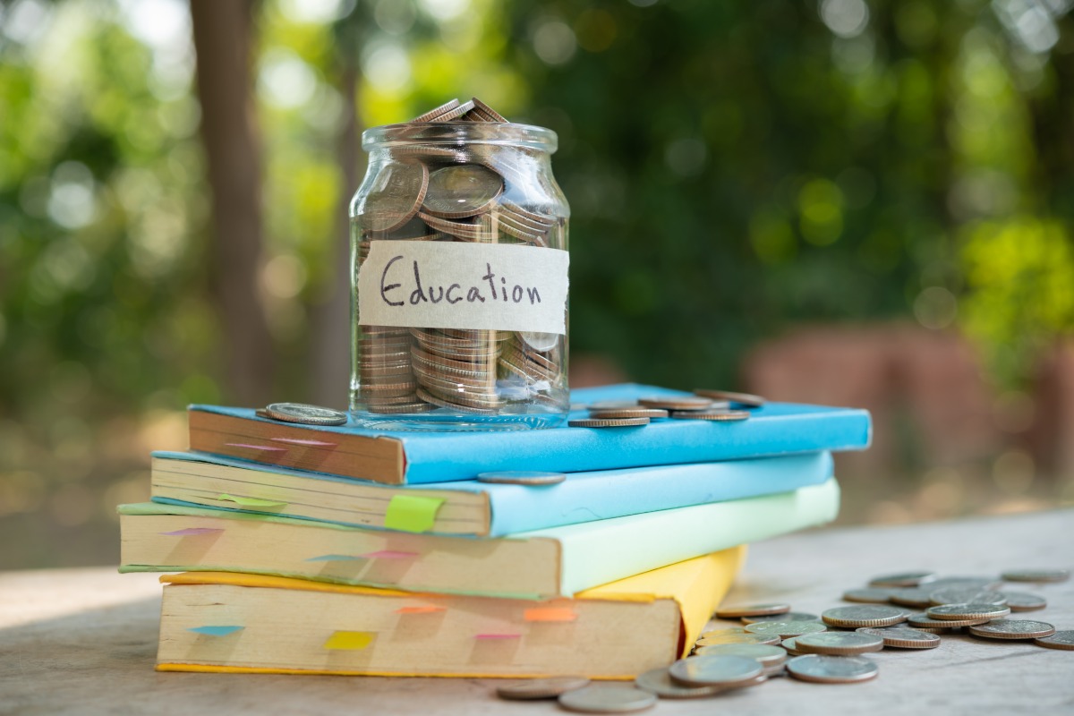 教育部學貸補助方案出爐 約54.6萬人受惠 putting money coins saving glass bottle concept investment mutual fund finance business placed textbook content money saving education