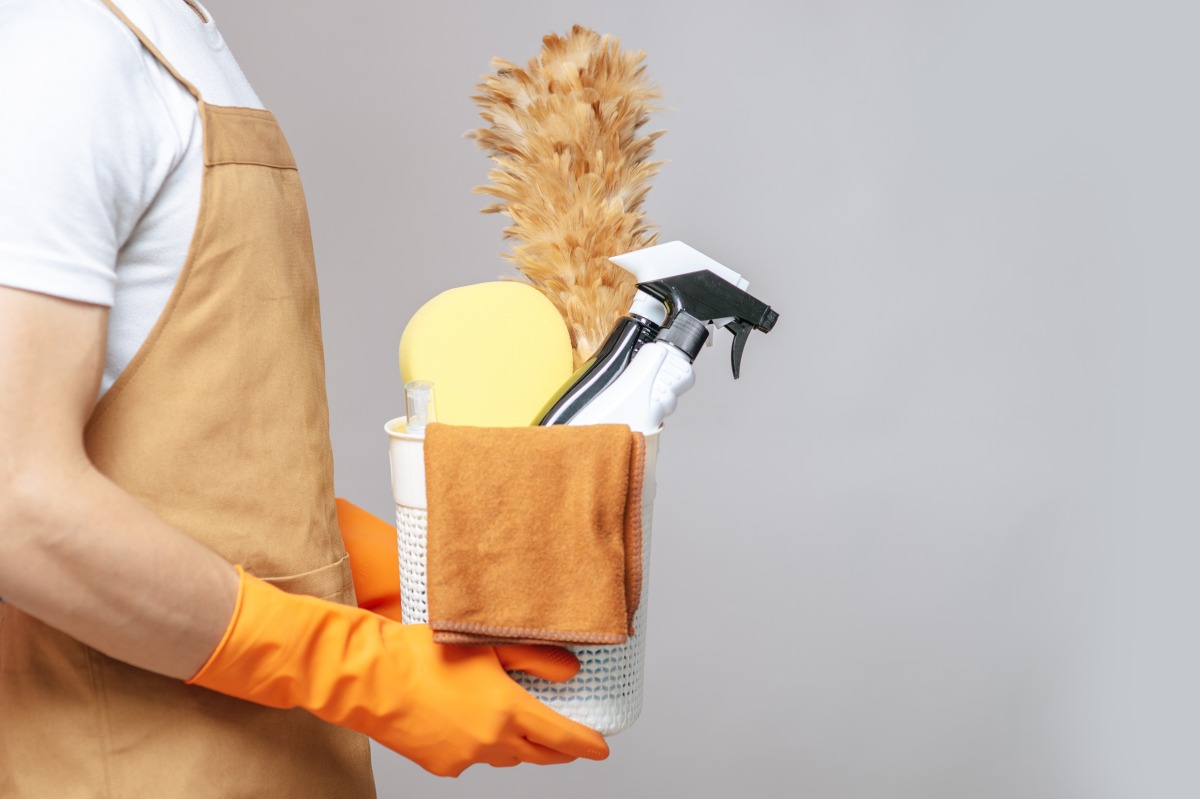 桃園文化基金會供訓練場地 助心智障礙者與職場接軌 side view close up hand young man apron rubber gloves holding basket cleaning equipment feather duster spray bottle sponge cloth wiping basket