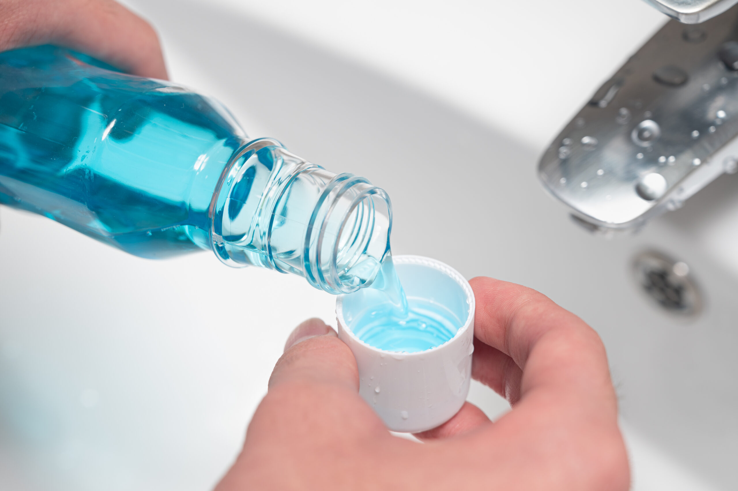 檢警不信「漱口水」害酒測超標 桃園男當庭漱口證清白 hand man pouring bottle mouthwash into cap scaled