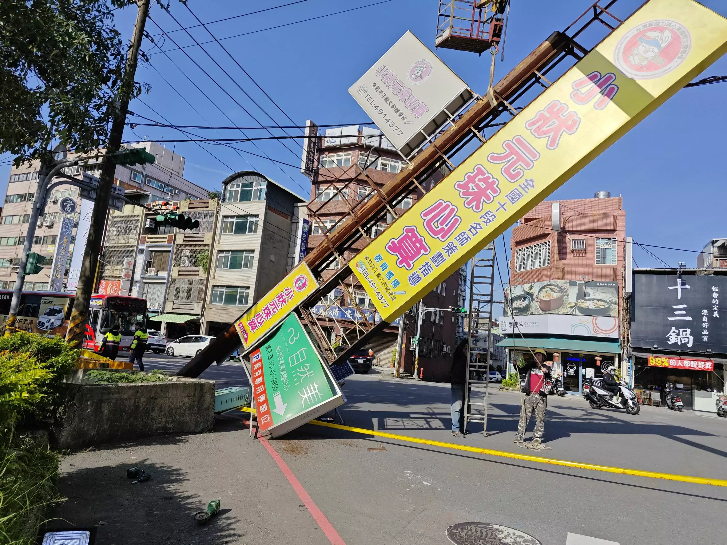 強風吹倒廣告招牌 鏽蝕基座連根拔起卡電線中 強風吹倒廣告招牌 鏽蝕基座連根拔起卡電線中