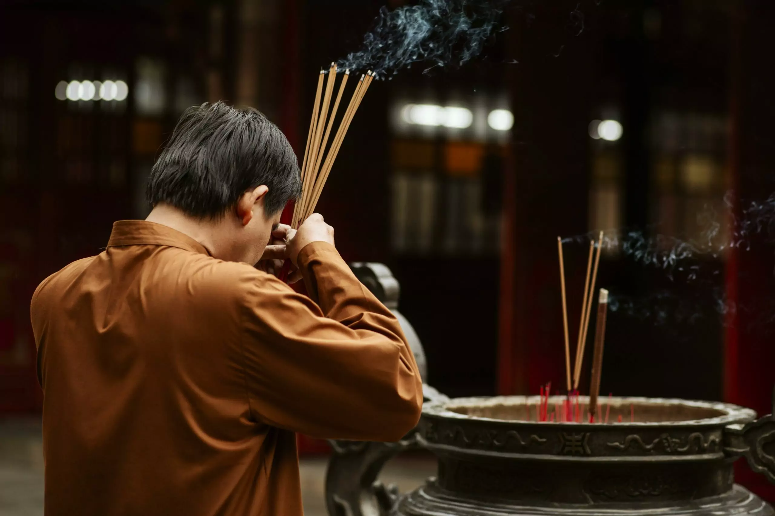 side view religious man temple with incense copy space scaled