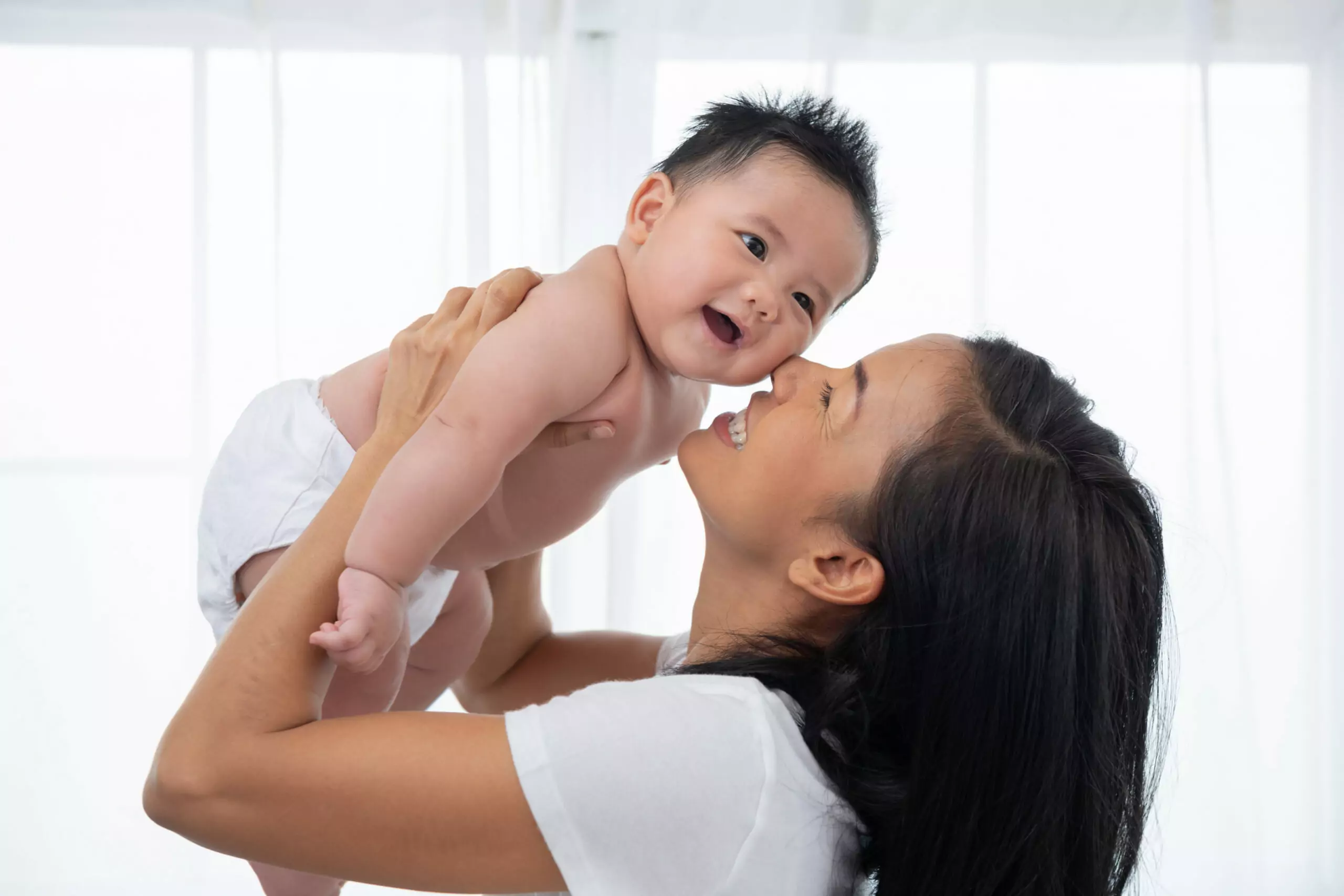 明年起生1胎拿10萬 立委:光靠補助無法有效解決低生育率 laughing mother lifting her adorable newborn baby son air 1 scaled