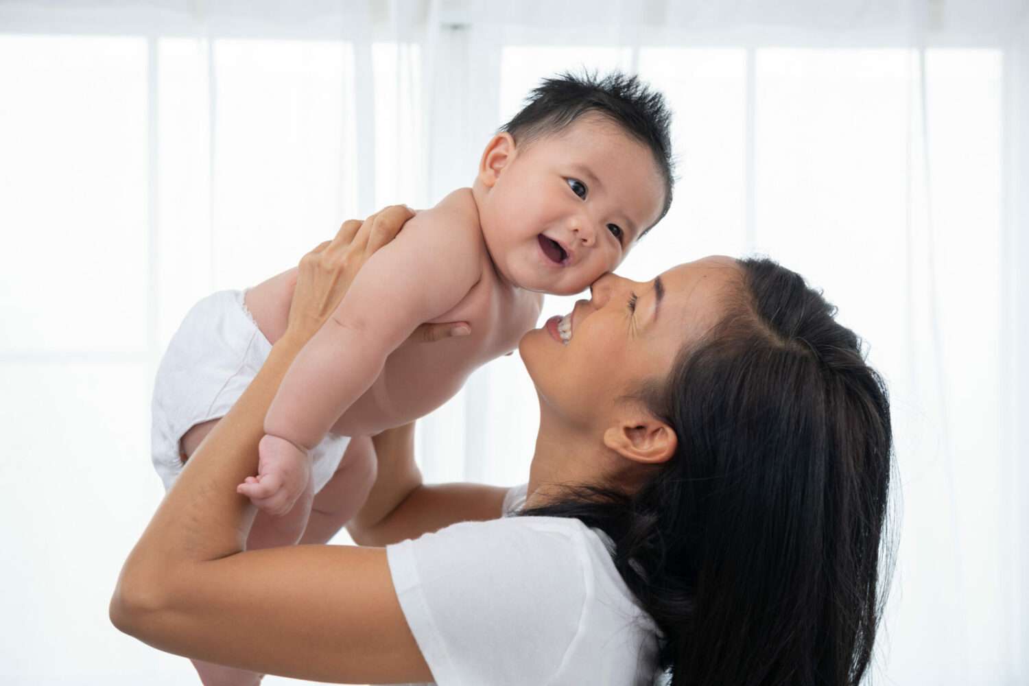 打造育兒友善環境 桃園勞動局鼓勵企業增設托育設施 laughing mother lifting her adorable newborn baby son air scaled e1705394189726