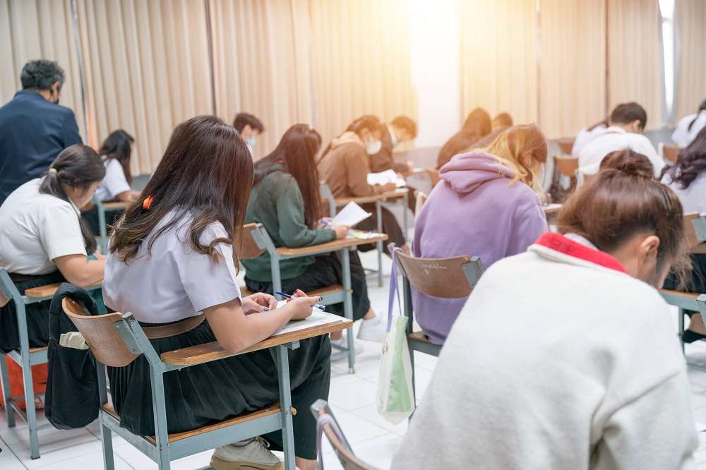 桃園勞動局補助大專開設在職進修專班 強化勞工職場競爭力 university students concentrating doing examinations classroom