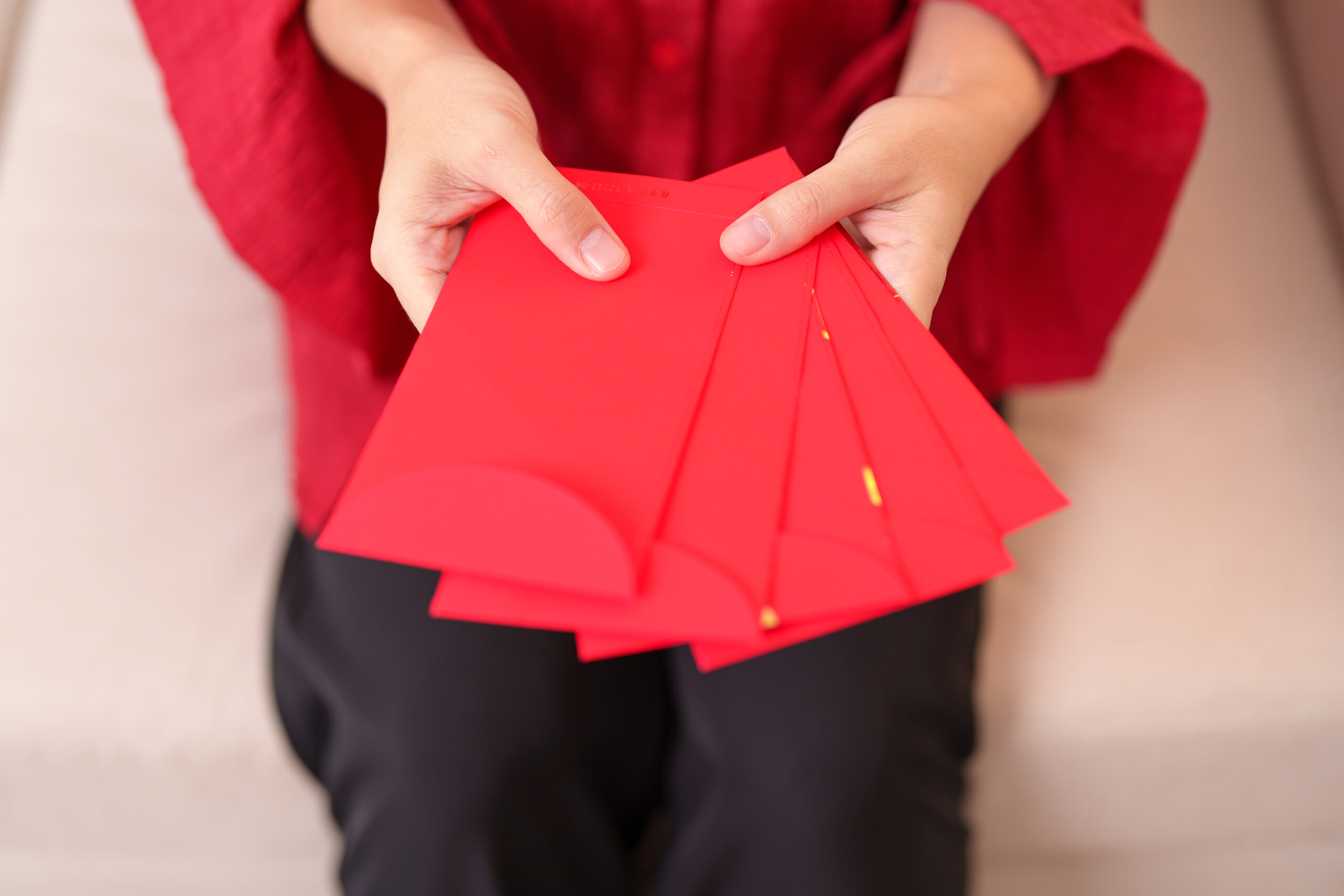 準備包紅包!央行曝新鈔兌換時間、地點 woman holding chinese red envelope money gift happy lunar new year holiday scaled