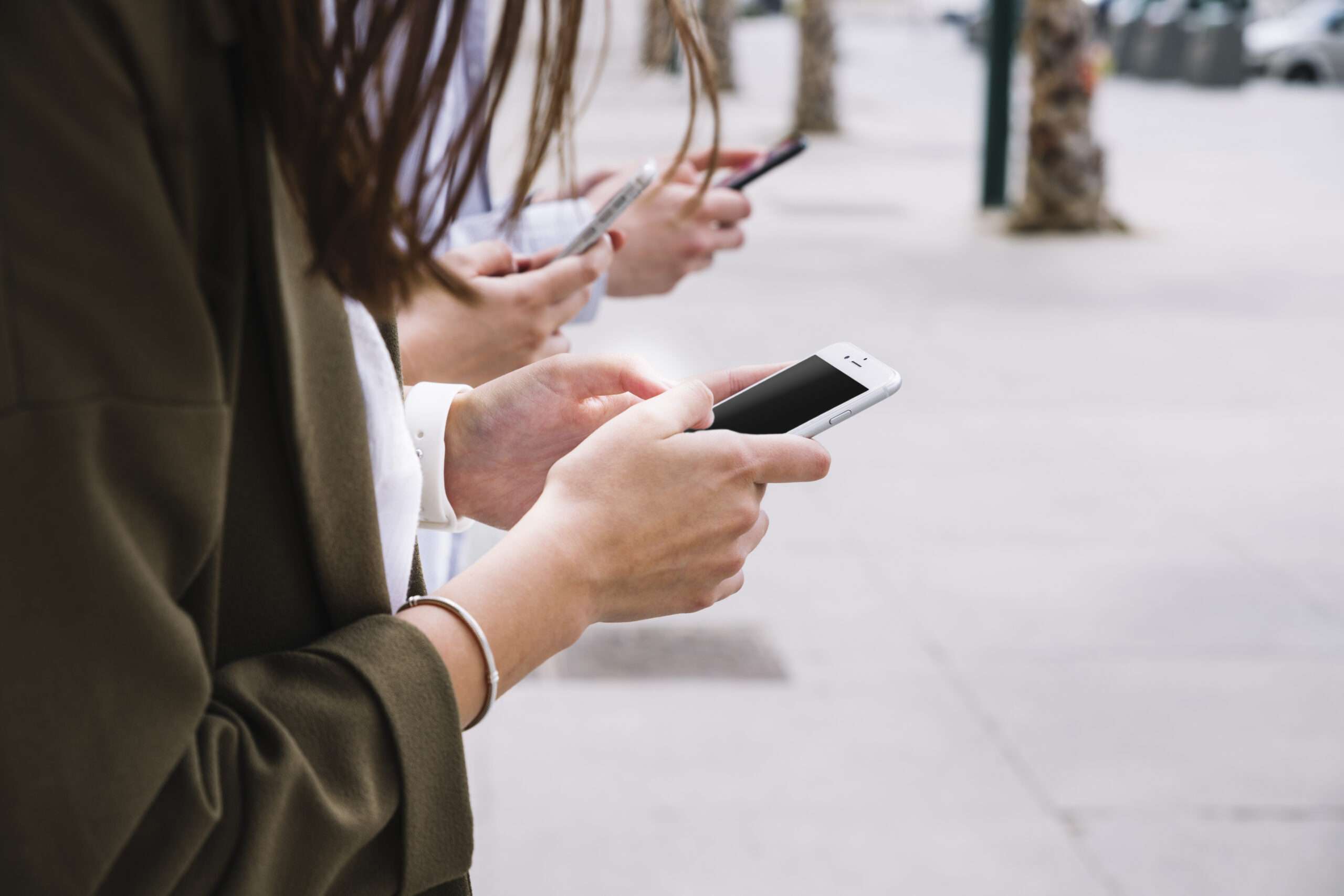 新學期開始!部桃醫傳授3妙招 教你擺脫手機成癮 three people using cell phone outdoors scaled
