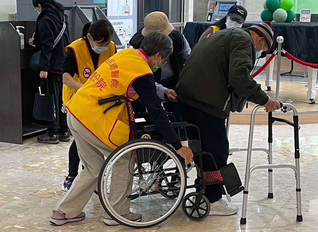 北榮桃園分院推動高齡友善服務 借用輔具好方便 2.志工主動協助行動不便使用輔具之民眾 0