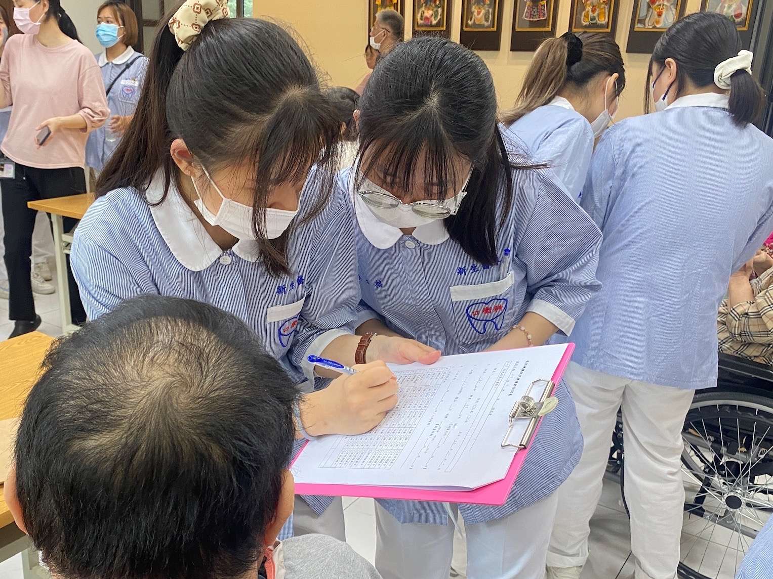 圖說二：學生葉容妤與許云格為住民進行口腔評估。圖：新生醫專提供。 0