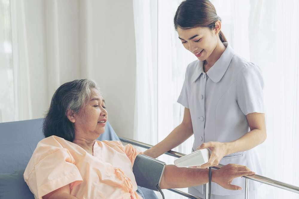 照顧市民健康!桃園公衛護理師過勞 一人服務11452人 nurse measuring blood pressure senior elderly woman hospital bed patients medical healthcare senior concept