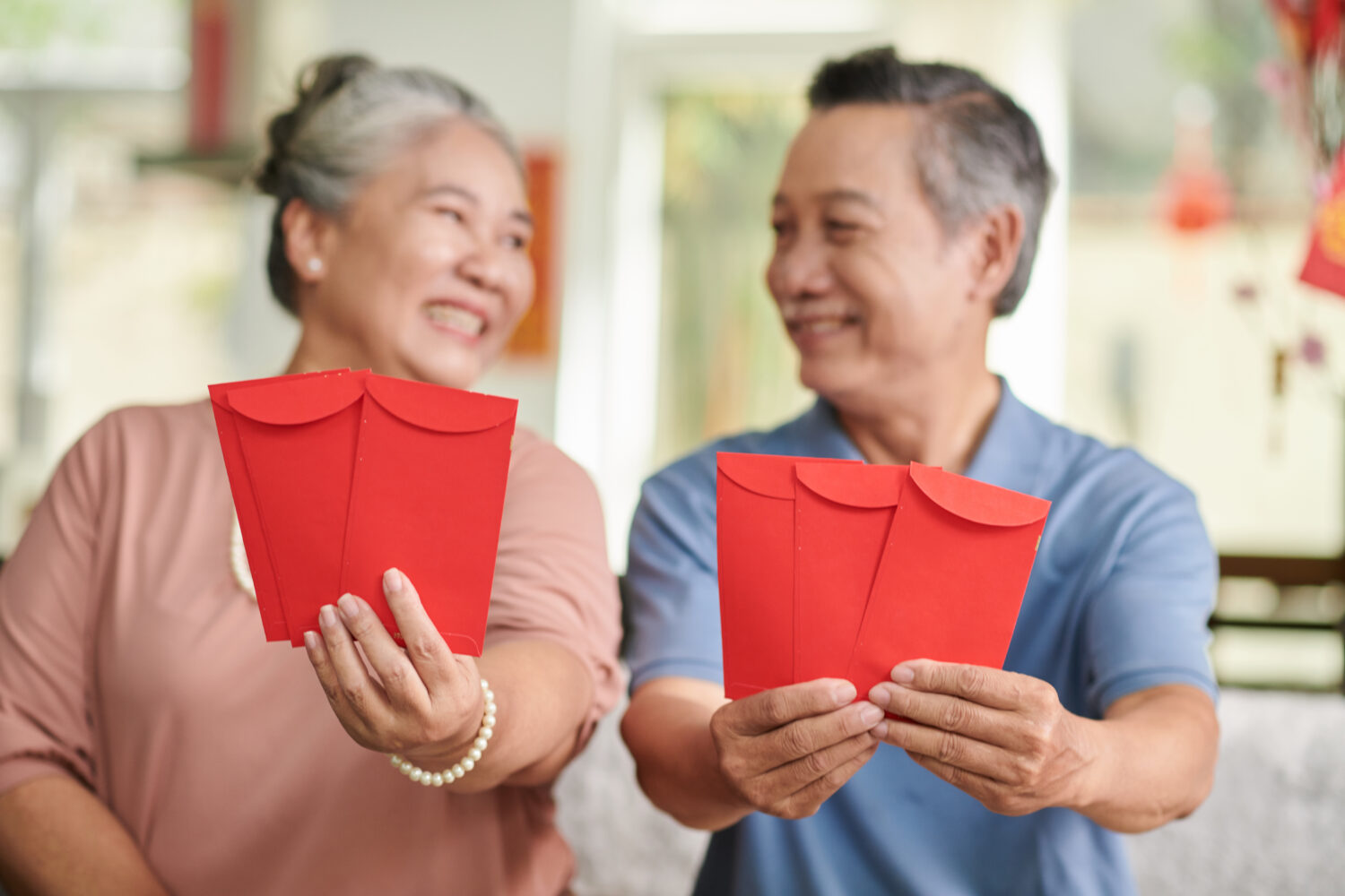 重陽敬老禮金來了!桃園長輩滿「這歲數」可領2萬 positive senior man woman showing red lucky money envelopes looking each other e1717238917909