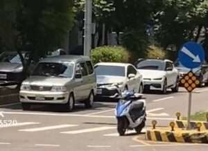 【有片】熱！騎士等紅燈怕曬太陽 竟拋下機車躲路旁乘涼