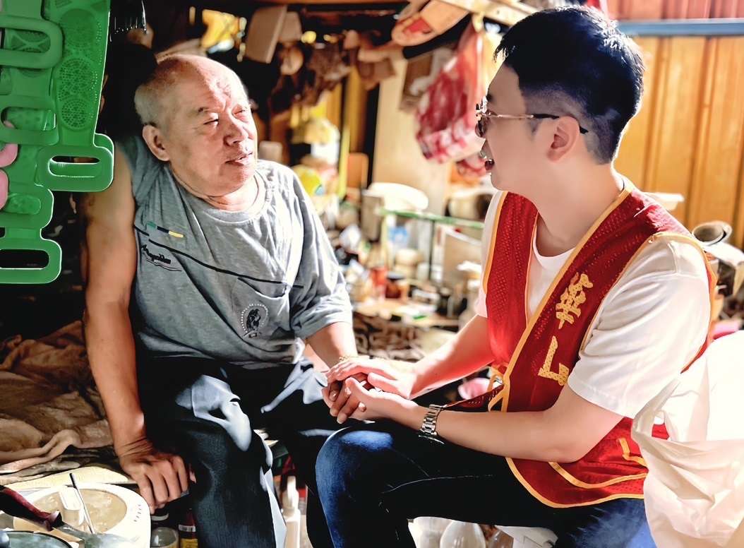 圖說：義工與史阿公相伴而坐，關心他的身體狀況。