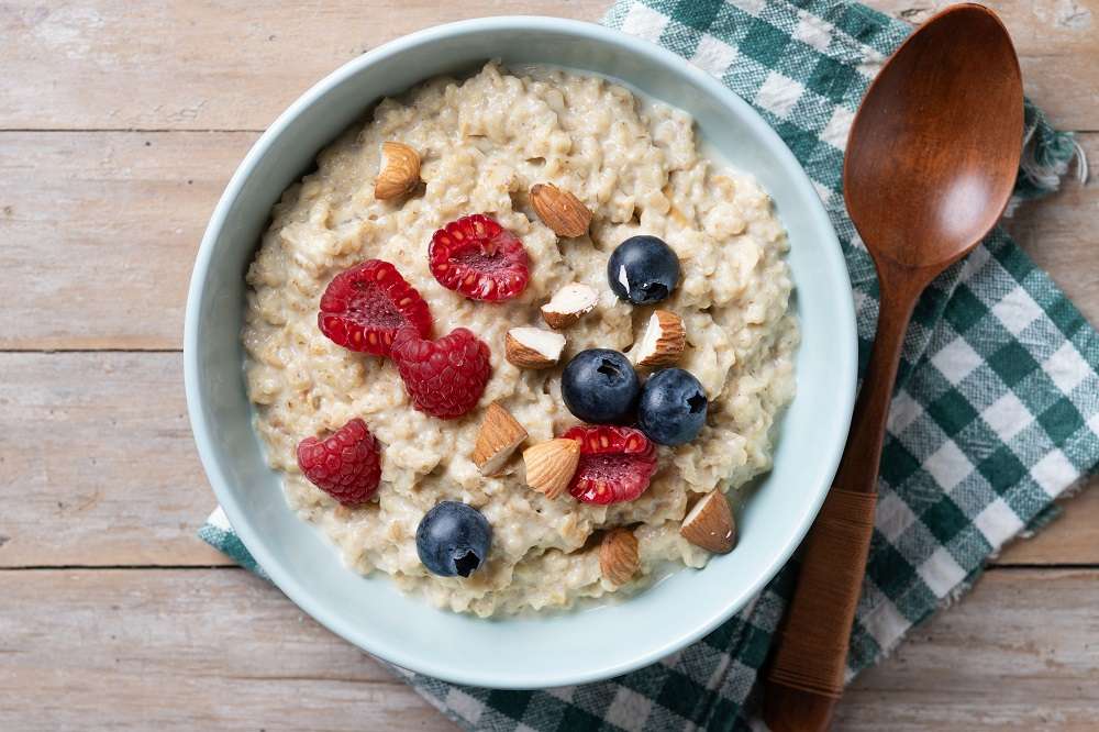 吃燕麥片減重忽略這件事 恐吃下額外熱量 oatmeal porridge with raspberries blueberries almonds bowl wooden table