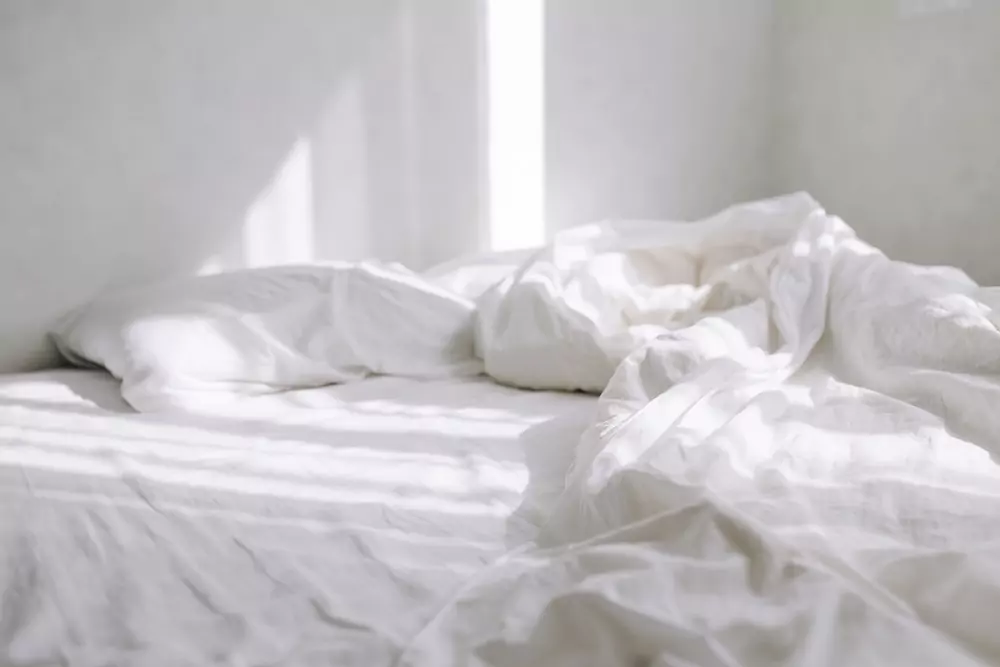 sun falls bed with white sheet bright bedroom