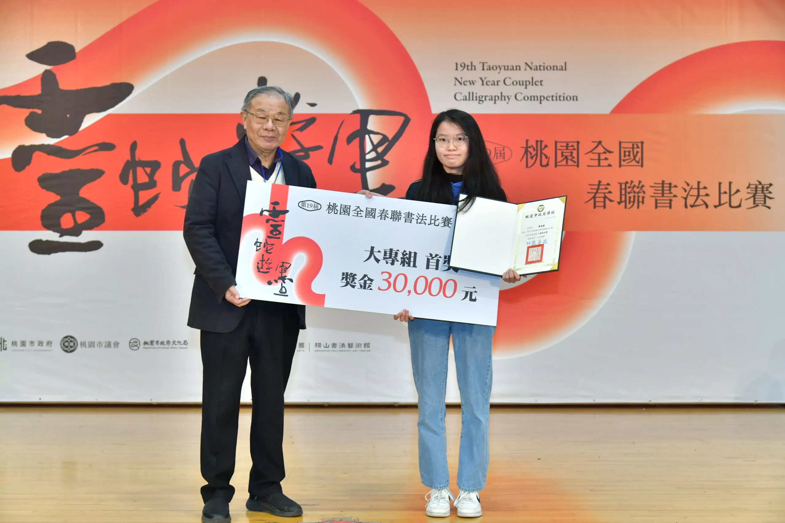 12 「靈蛇遊墨 第19屆桃園全國春聯書法比賽」頒獎典禮由評審委員張炳煌頒發大專組首獎 0 scaled