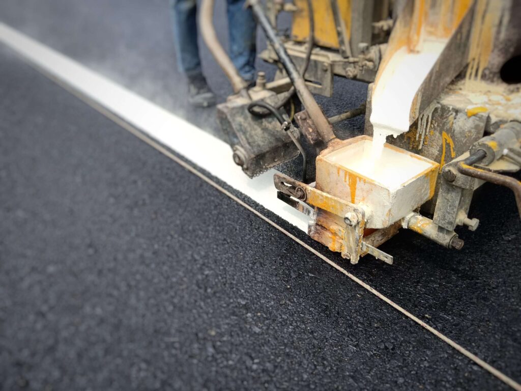 low section man making marking road with machine scaled