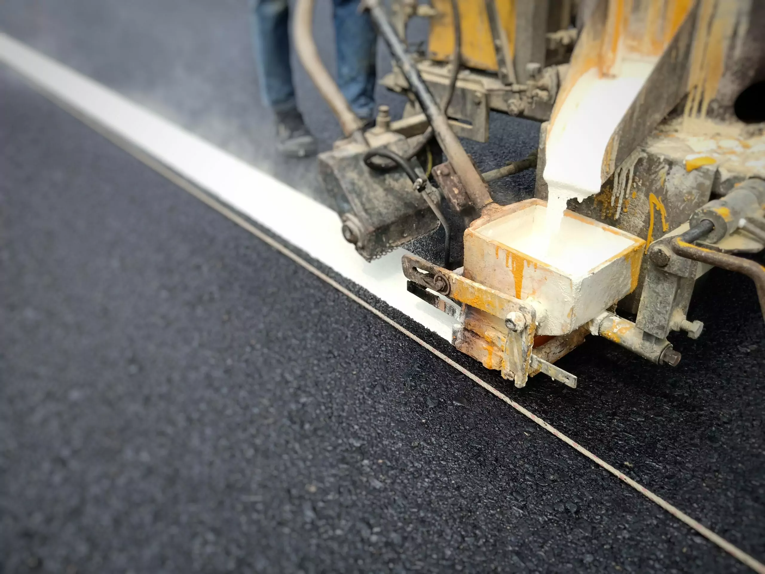 low section man making marking road with machine scaled