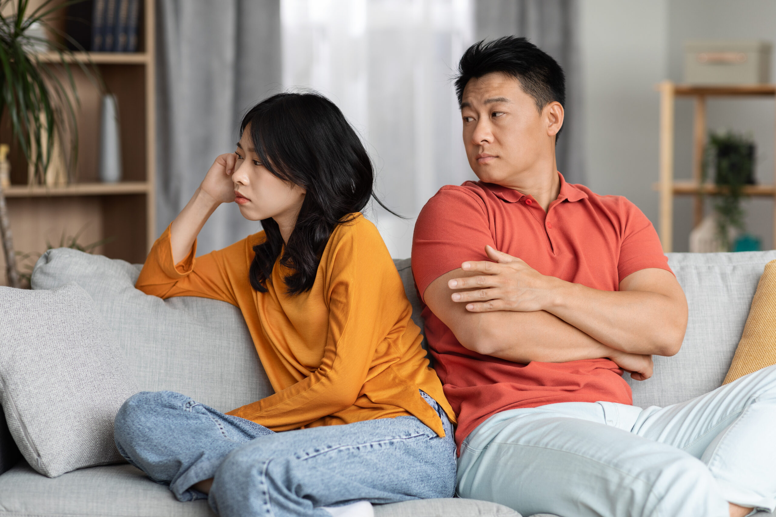 花錢顧家卻換來冷臉 桃園工程男婚姻崩潰文引爆共鳴 upset asian couple sitting couch home scaled