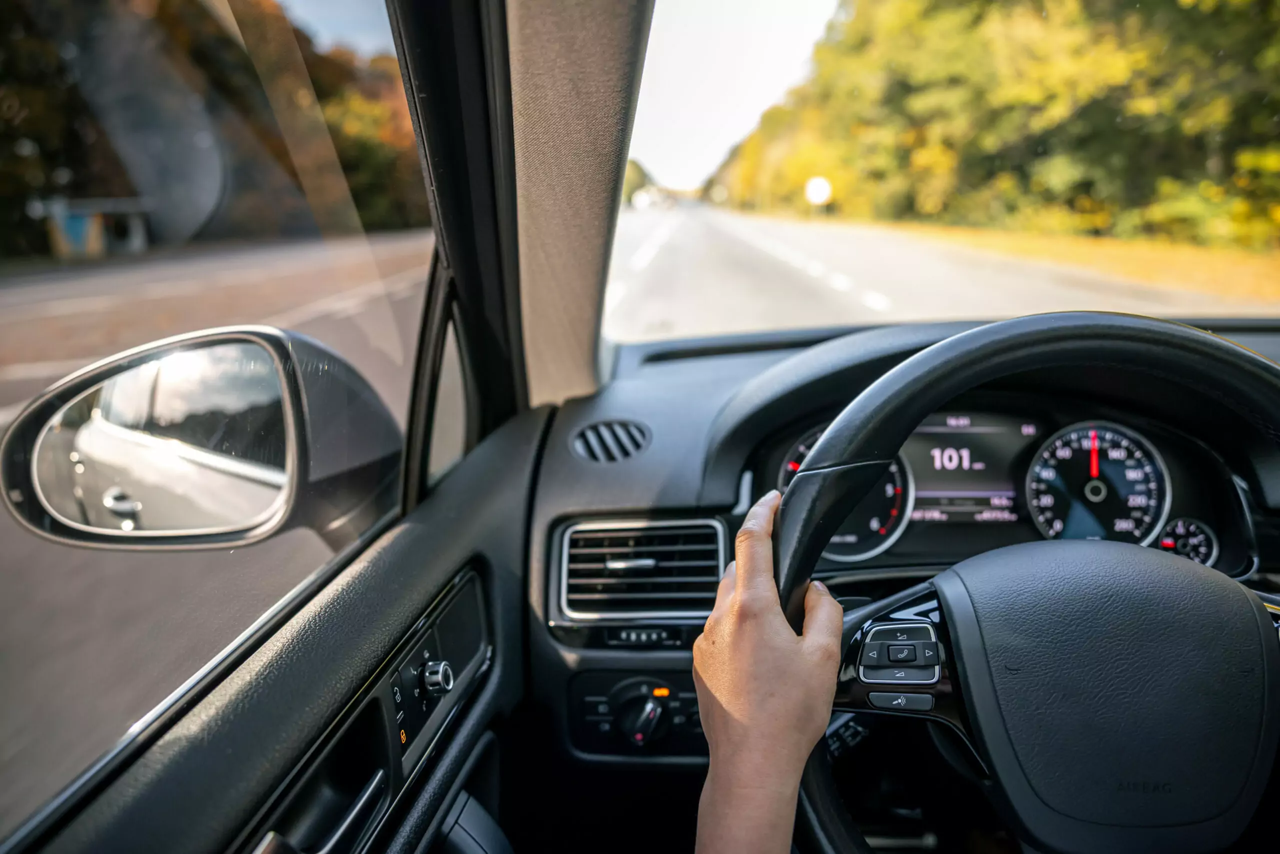 woman drivers hands steering wheel inside car scaled