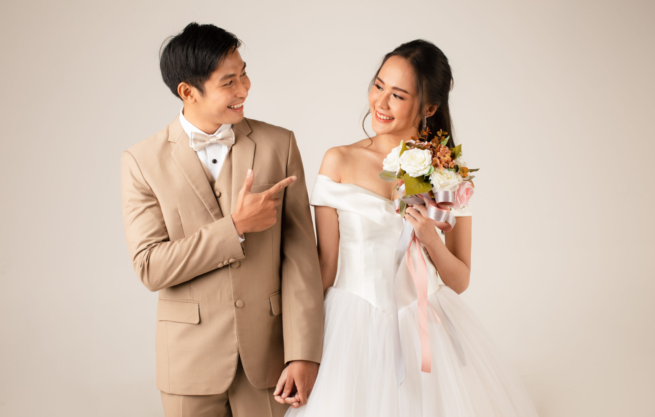 婚禮非必要?年輕世代掀省錢風潮改做「這些事」 young attractive asian couple man wearing beige suit woman wearing white wedding gown standing together holding hands concept pre wedding photography scaled
