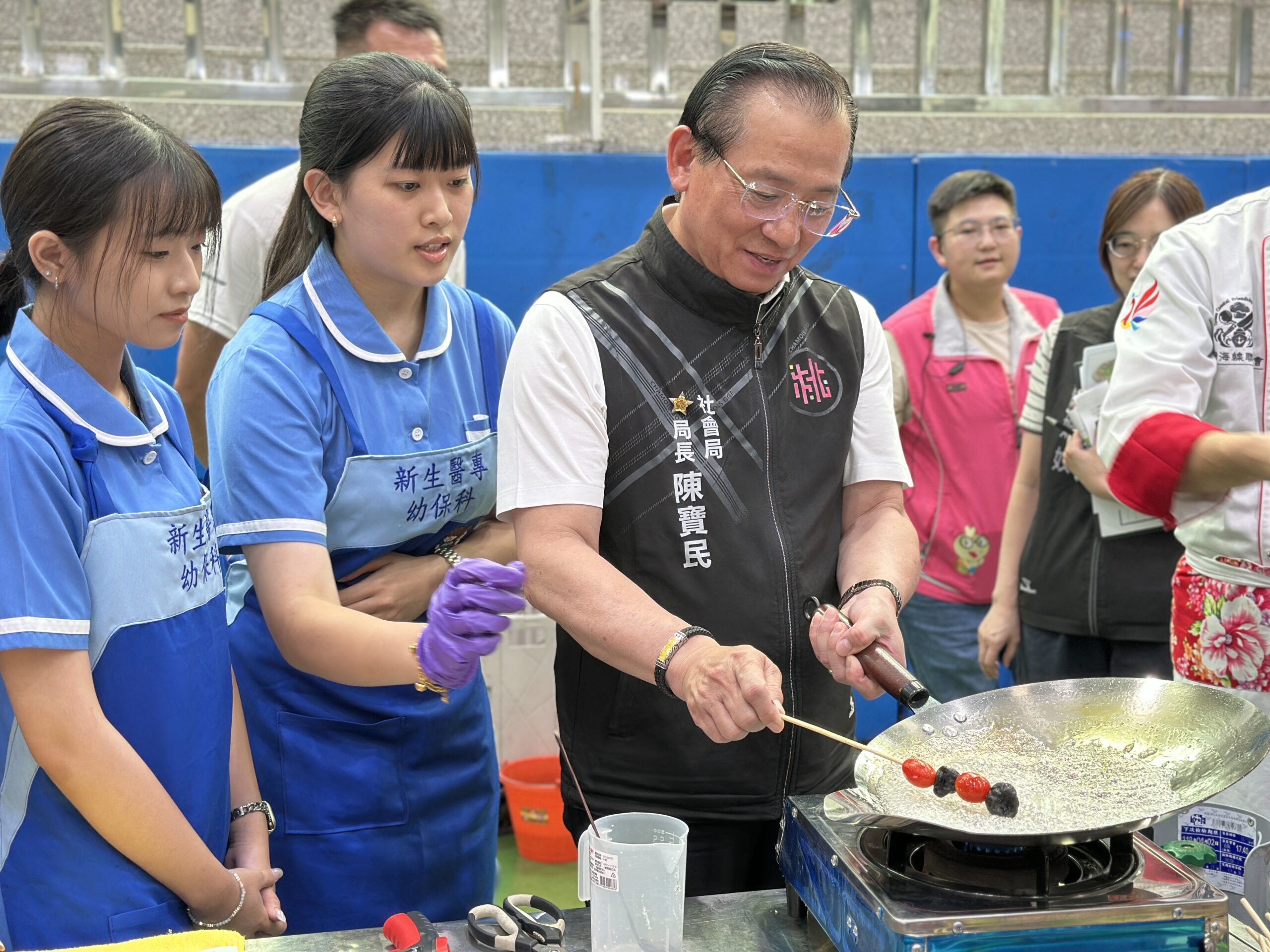 桃園關懷據點美食大賞複賽新生醫專登場 在地食材滿足長輩味蕾 圖說二:社會局局長陳寶民體驗「手作糖葫蘆」。圖:新生醫專提供 0 scaled
