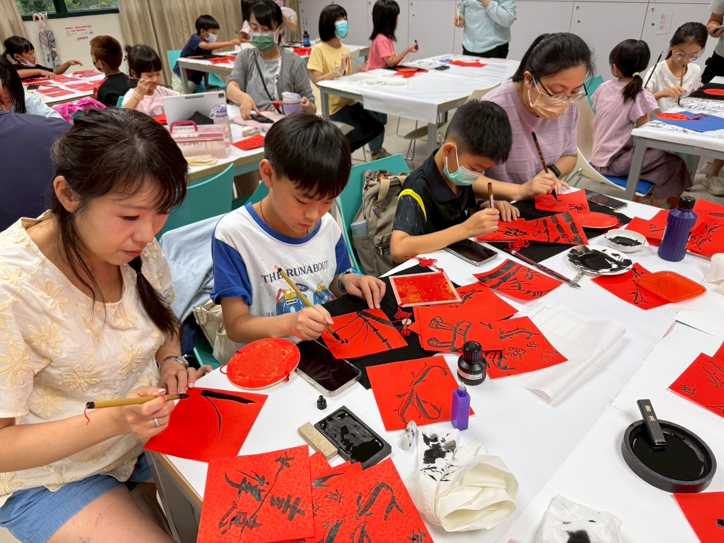 家長帶著孩子一起學習書畫的畫面十分溫馨