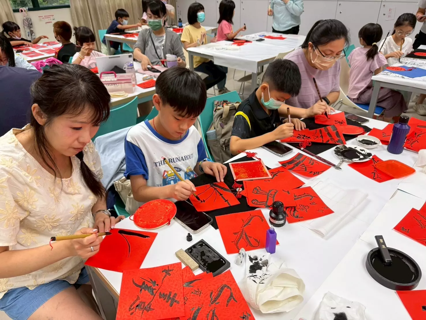 桃市圖中壢分館舉辦書法大師講堂 9位重量級名家輪番開講 家長帶著孩子一起學習書畫的畫面十分溫馨