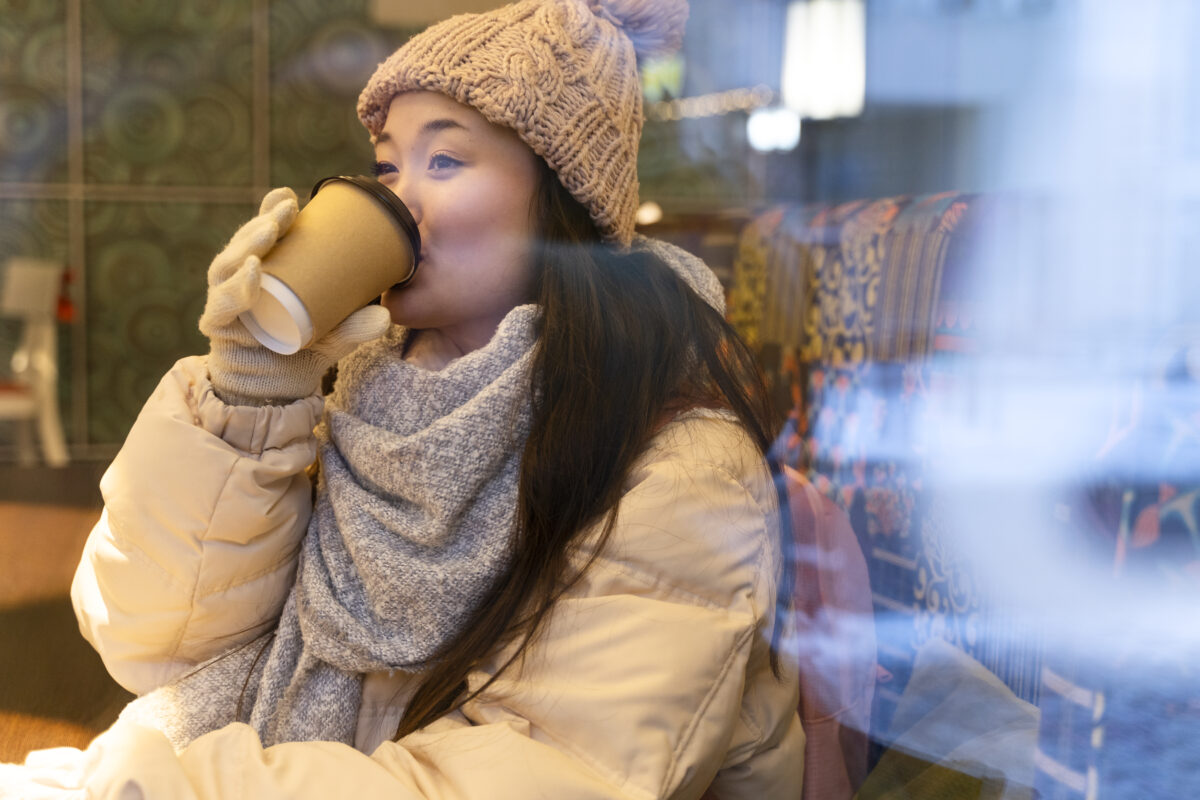 young woman drinking hot beverage