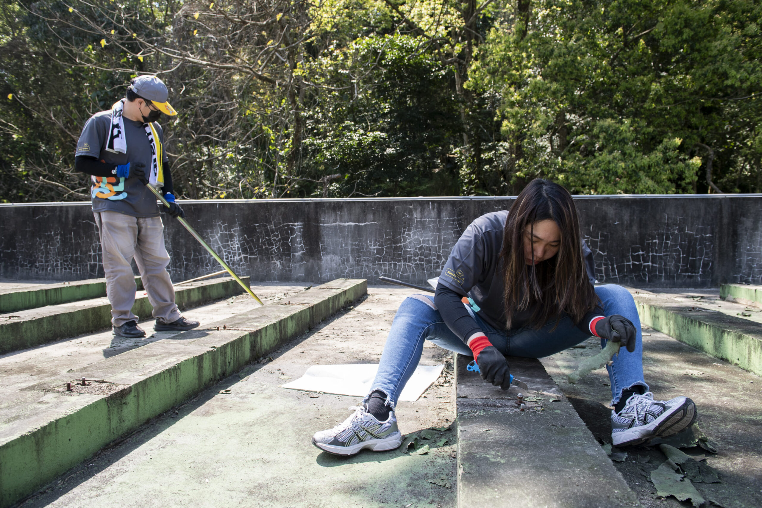 志工們分組刮除屋頂已破損防水PU及地面清潔，針對頂樓防水進行補強 scaled