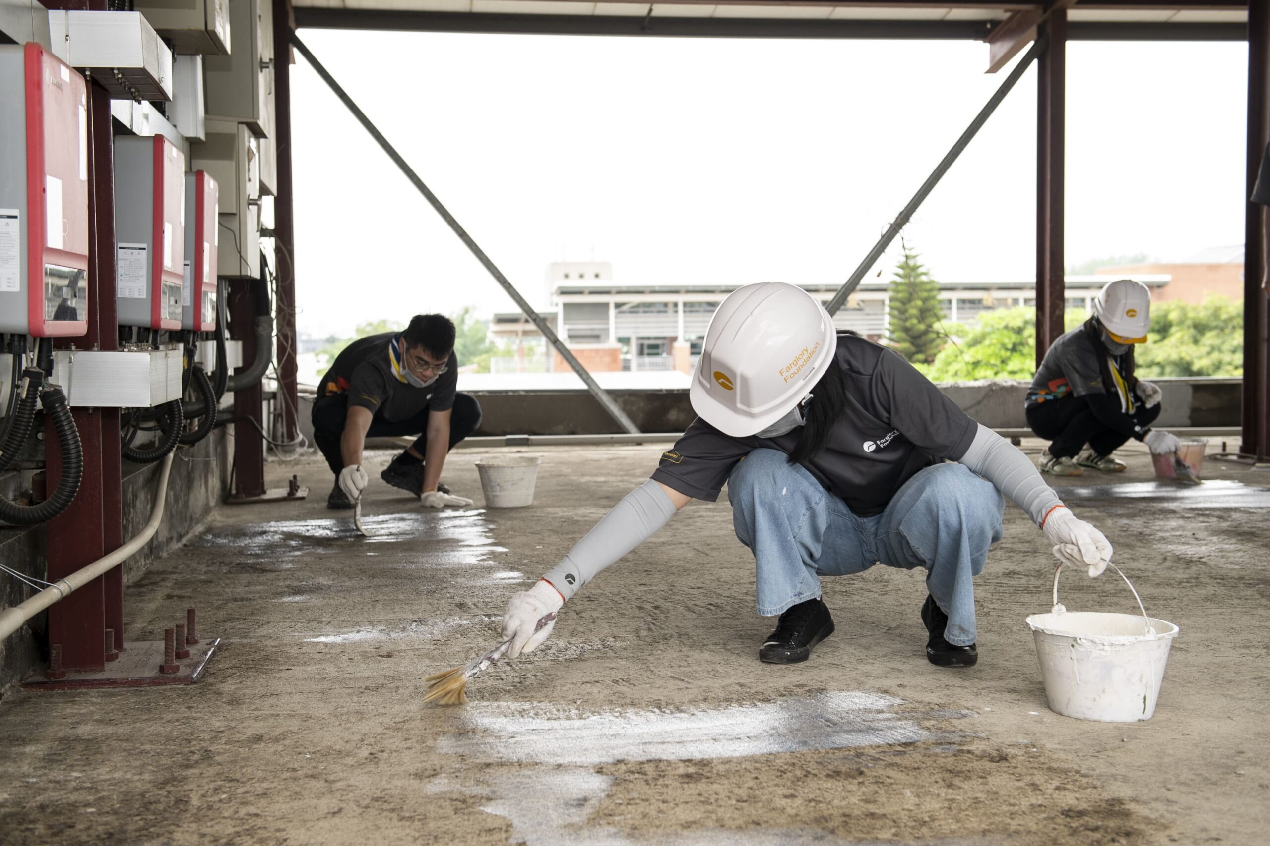 地面灰塵清除乾淨後，遠雄志工塗刷第一層稀釋防水漆，填補細微孔隙。 0 scaled